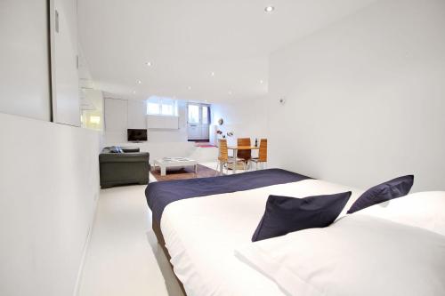 a bedroom with a white bed and a living room at Romantic Jordaan Canalsuite near Anne Frank House in Amsterdam