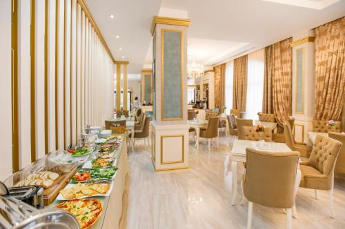a dining room with tables and chairs with food at Gold Tbilisi Hotel in Tbilisi City