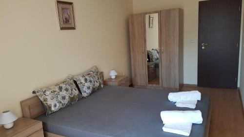 a living room with a blue couch with towels on it at Zefira Apartments in Pomorie