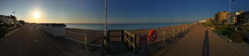 a fence next to a beach with the ocean at SeaScape in Bexhill