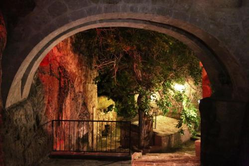 an archway with a tree and a fence at Kapadokya Ihlara Konakları Otel Konak Odaları in Guzelyurt