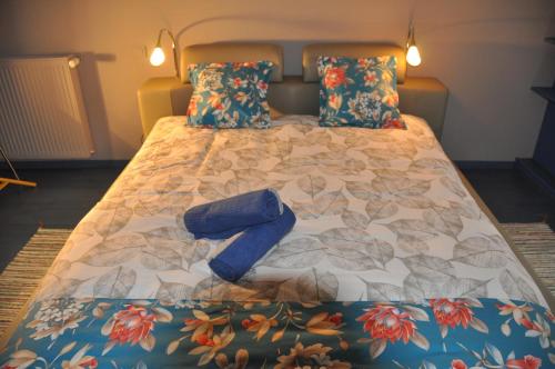 a bed with two blue pillows on it at Chambre d'hôtes Sauternais in Pujols-sur-Ciron