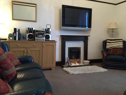 a living room with a fireplace with a tv above it at 5B, Market Place flats in Barnard Castle