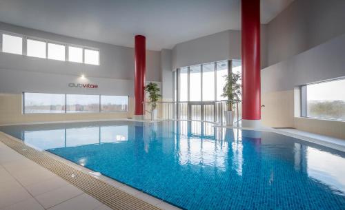a large swimming pool with blue water in a building at Clayton Hotel Limerick in Limerick