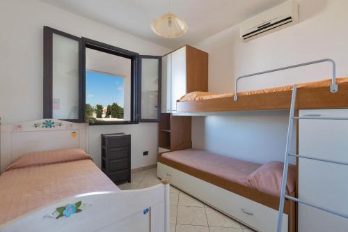 トッレ・ラピッロにあるAppartamento Solaris by BarbarHouseのベッドルーム1室(二段ベッド2台、窓付)が備わります。