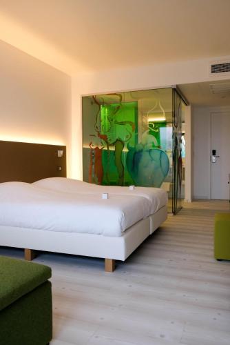 a bedroom with a large bed with a painting on the wall at Corbie Lommel Ring in Lommel