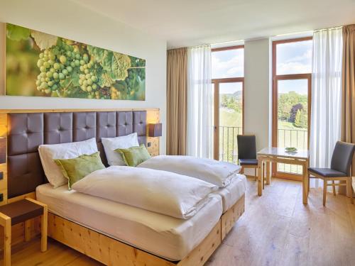 1 dormitorio con 1 cama grande, mesa y sillas en Weingut Taggenbrunn en Sankt Veit an der Glan