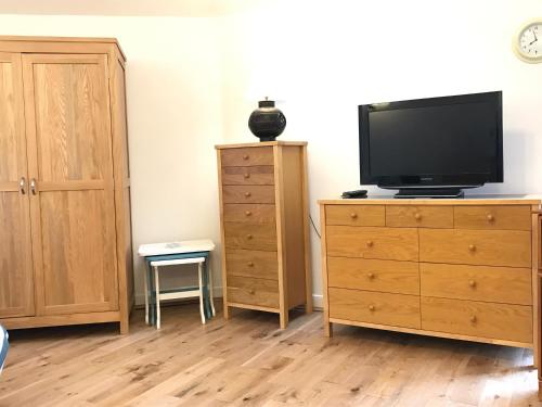 a bedroom with a dresser with a tv on it at The Annex - Penzance town centre with parking in Penzance