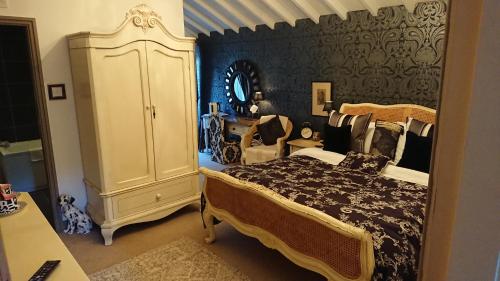 a bedroom with a large bed and a dresser at Teardrop Cottage in Knaresborough