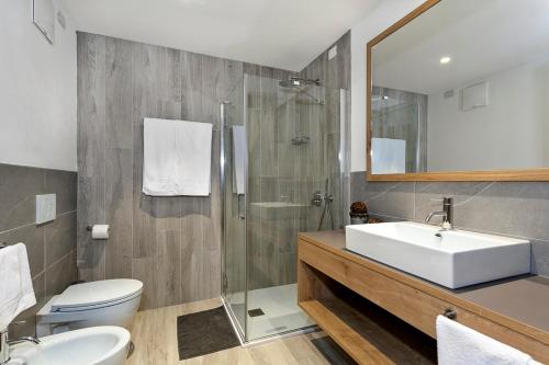Un baño con lavabo, inodoro y ducha. en Appartamento Fuoco, en Andalo