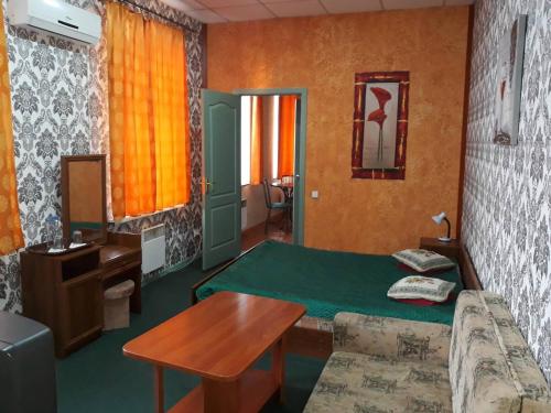 a room with a bed and a table and a desk at EuroLux Hotel in Poltava