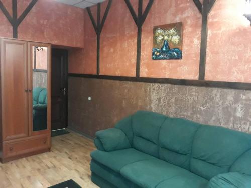 a living room with a green couch in a room at EuroLux Hotel in Poltava