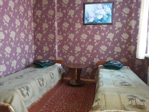 a room with two beds and a table in it at EuroLux Hotel in Poltava