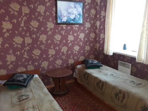 a room with two beds and a table and a window at EuroLux Hotel in Poltava