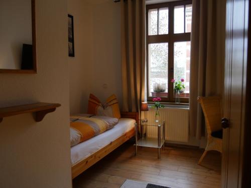 een kleine slaapkamer met een bed en een raam bij Pension La rose in Brandenburg an der Havel