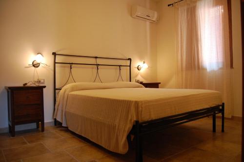 a bedroom with a bed and two lamps on tables at L'Agave in SantʼAntìoco