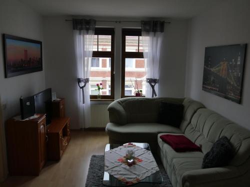 a living room with a couch and a tv at Pension La rose in Brandenburg an der Havel