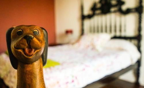 a wooden figurine of a dog in front of a bed at Azores Dream Hostel in Ponta Delgada