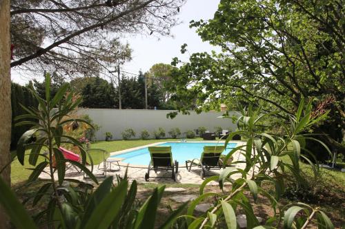 - une piscine avec quatre chaises dans la cour dans l'établissement ENTRE AVIGNON et PONT DU GARD, à Rochefort-du-Gard
