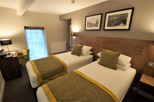a hotel room with two beds and a window at New Park Hotel in Carmarthen