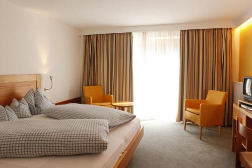 una camera d'albergo con letto e TV di Hotel Stefaner a Tires