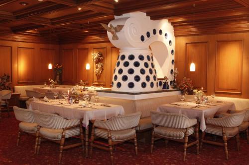 uma sala de jantar com mesas e um vaso grande em Hotel Stefaner em Tires