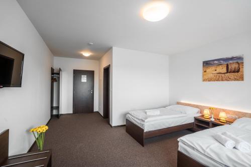 Una cama o camas en una habitación de Hotel Na Farmě Choťovice