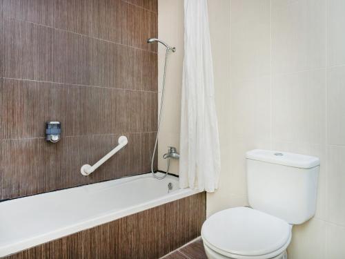 La salle de bains est pourvue de toilettes, d'une baignoire et d'une douche. dans l'établissement Qawra Point Holiday Complex, à San Pawl il-Baħar