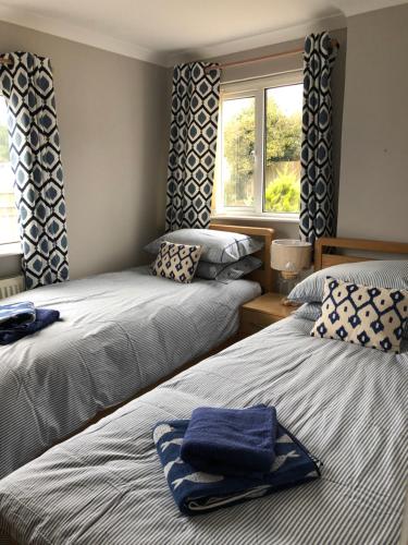 サンダースフットにあるWogan Cottageのベッドルーム1室(青いタオル付きのベッド2台付)