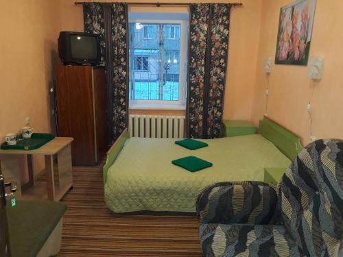 a small room with a bed and a window at Hotel Europlus in Poltava