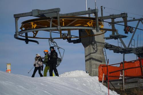 a group of people standing on a ski lift at Champoussin Lodge in Champoussin