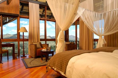 a bedroom with a bed and large windows at Gocheganas Lodge in Gocheganas