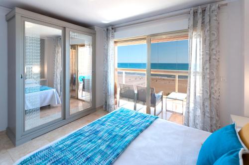 a bedroom with a bed and a view of the ocean at Ag Bermudas Deluxe in Gandía
