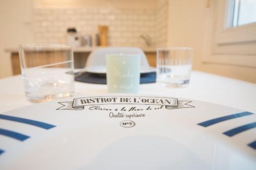 une table avec deux verres et un panneau sur celle-ci dans l'établissement Studio "L'OCEANE", à Lorient