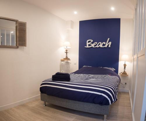 Un dormitorio con una cama con la palabra entrenador en la pared en Studio "L'OCEANE", en Lorient