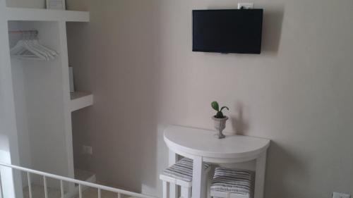 a room with a white table and a tv on the wall at Corte Moline in Gallipoli