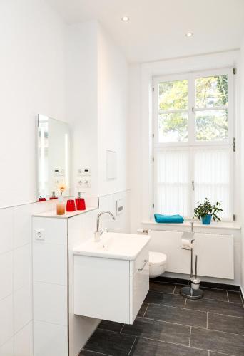 a white bathroom with a sink and a toilet at Komfortwohnung Innenstadt an der Schelfkirche in Schwerin