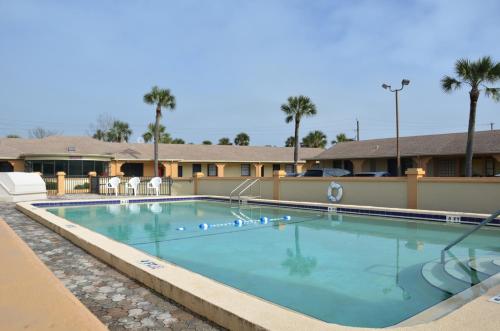 a swimming pool at a resort with palm trees at The Lion Inn - Saint Augustine in Saint Augustine
