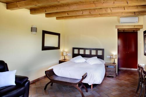 1 dormitorio con 1 cama blanca y 1 silla en Sa Perafita - MF, en Cadaqués