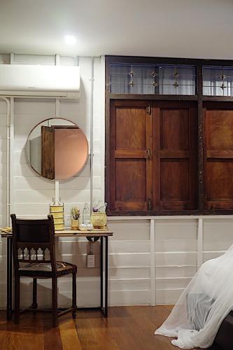 a bedroom with a table and a mirror and a chair at The Good Days in Udon Thani