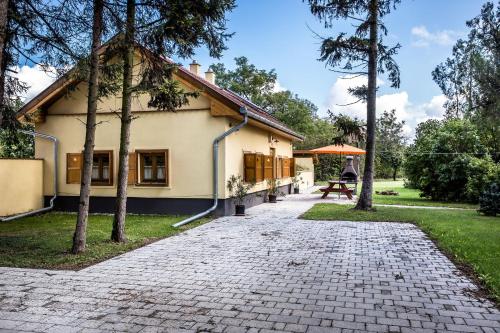 a house with a brick path in front of it at Török Vendégház in Jobaháza