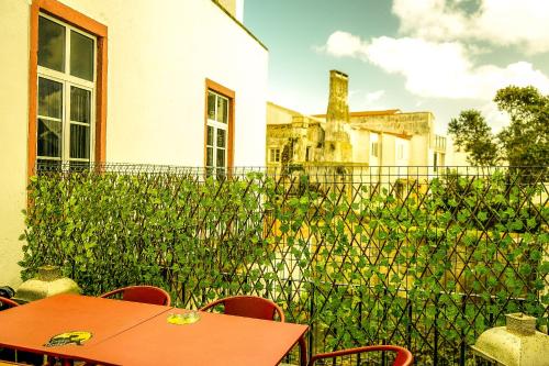 un patio con mesa, sillas y una valla en Azores Dream Hostel en Ponta Delgada