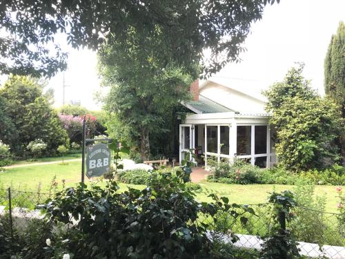 a house with a sign in front of a yard at Rosewood Corner, Clarens in Clarens