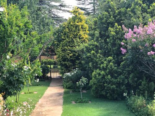 a garden with trees and a fence and a path at Rosewood Corner, Clarens in Clarens