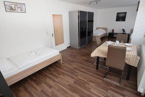 a room with a bed and a table and chairs at Apartment Gablenberg in Stuttgart