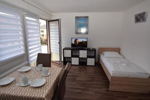 a bedroom with a table and a bed and a television at Apartment Gablenberg in Stuttgart