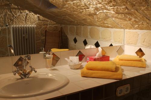 lavabo con 2 toallas y espejo en Hotel Villa Vital Munster, en Munster im Heidekreis
