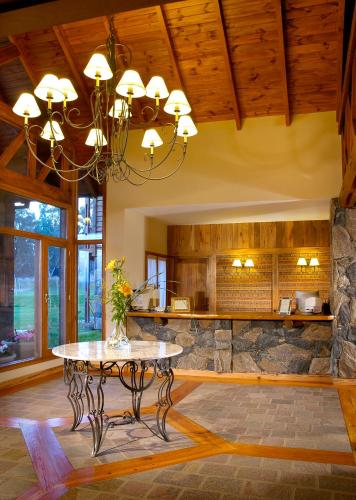 a living room with a table and a stone wall at Chamonix Posada & Spa in Villa General Belgrano