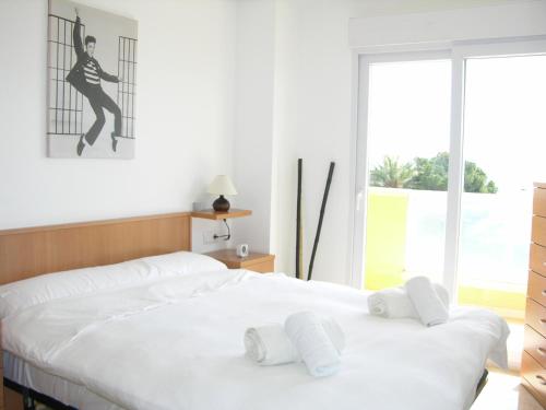 1 dormitorio con 1 cama con 2 almohadas blancas en Playa Principe - 6507, en La Manga del Mar Menor