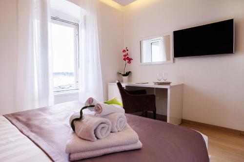 1 dormitorio con toallas en una cama con escritorio en Luxury rooms Skystar-Split, en Split